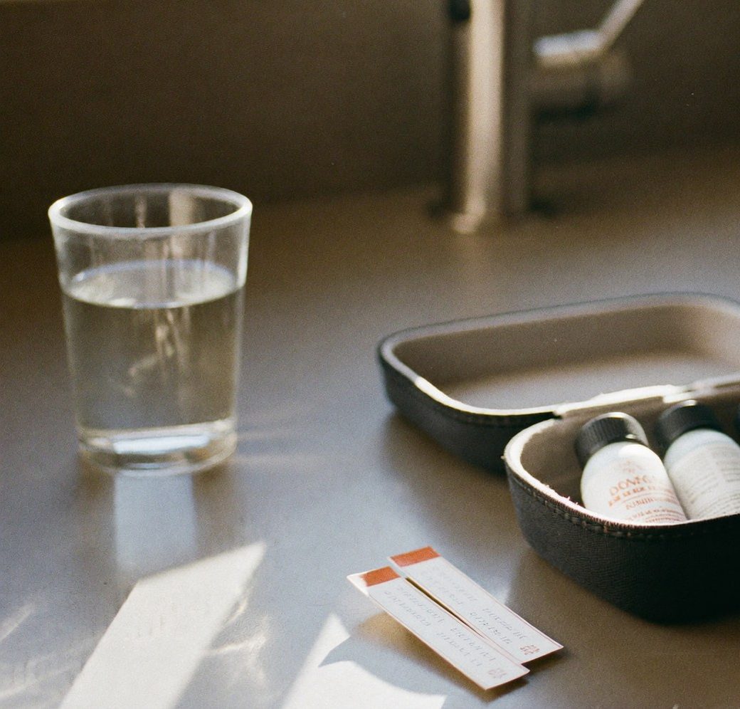 A glass of clean, filtered water next to a home water test kit on a Concord, NC kitchen counter